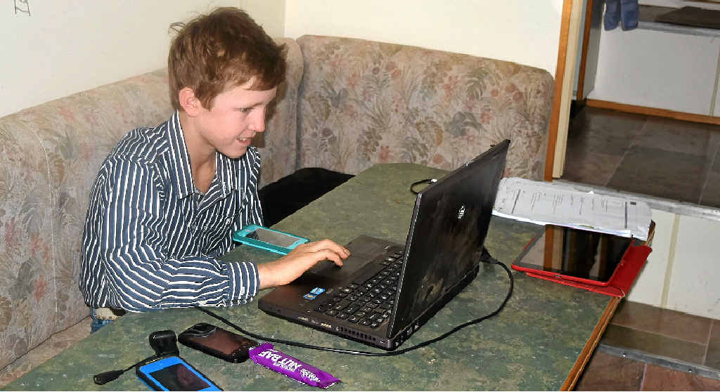 Eleven-year-old Luke Philp on the phone to his teacher in Emerald. Eleven-year-old Luke Philp on the phone to his teacher in Emerald.